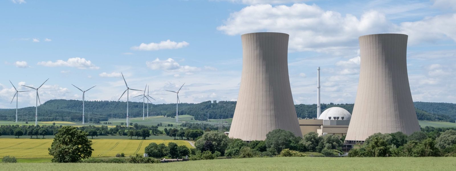 Zielony krajobraz z elektrownią atomową i wiatrakami